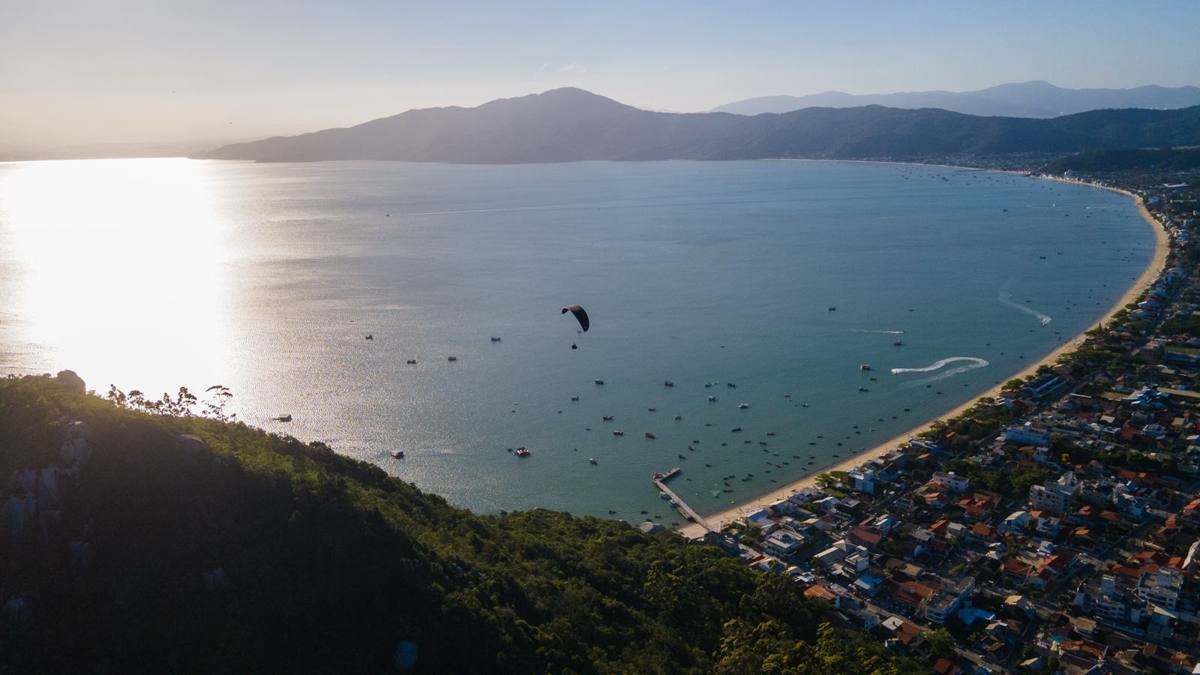 Parapente no pôr do sol sobre a baía